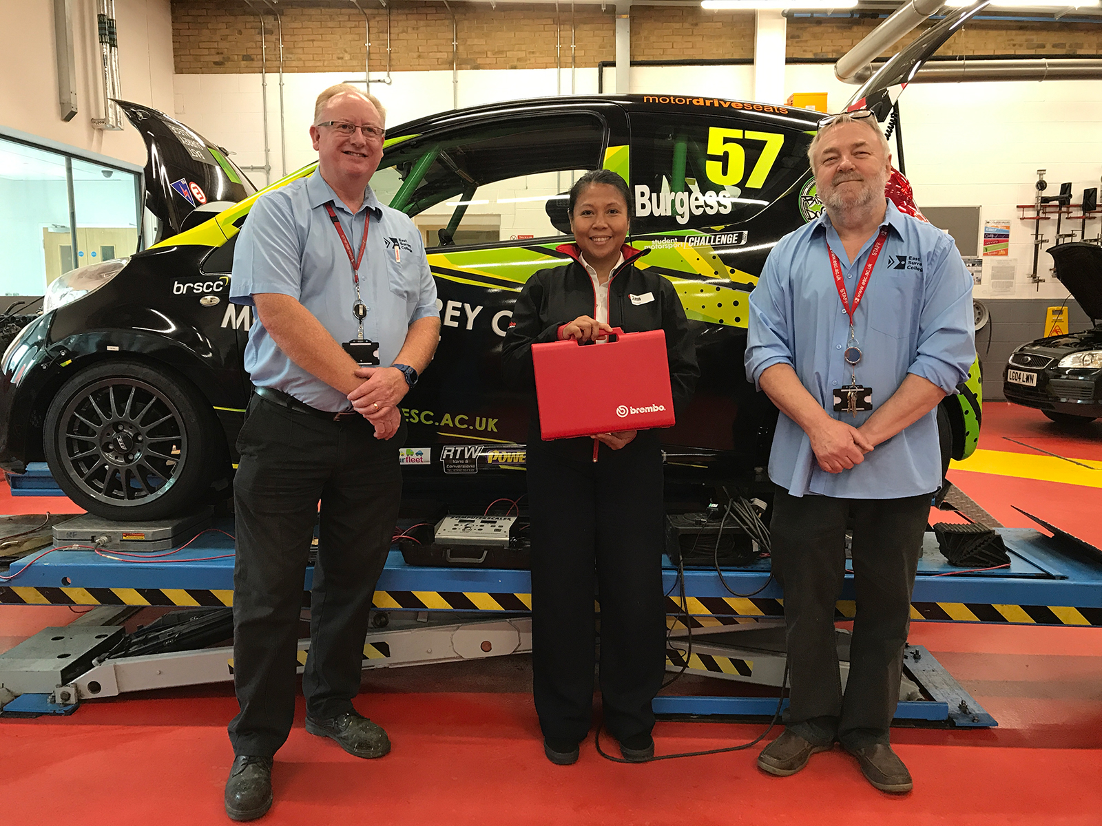 A representative from Brembo Brakes presents a prize to East Surrey College's Motor Vehicle Department