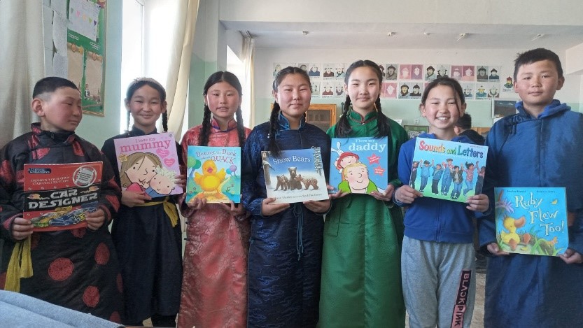 Group of Mongolian children holding donated books