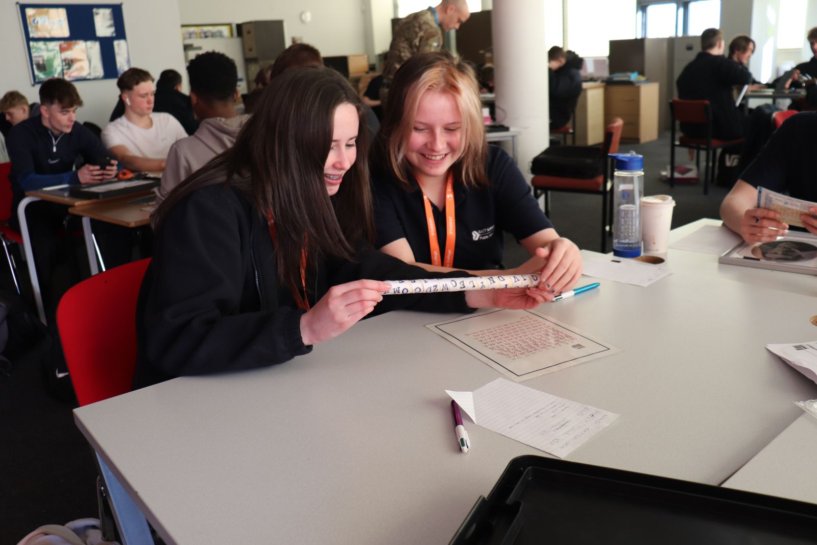 Two public services students looking at a code on a piece of fabric