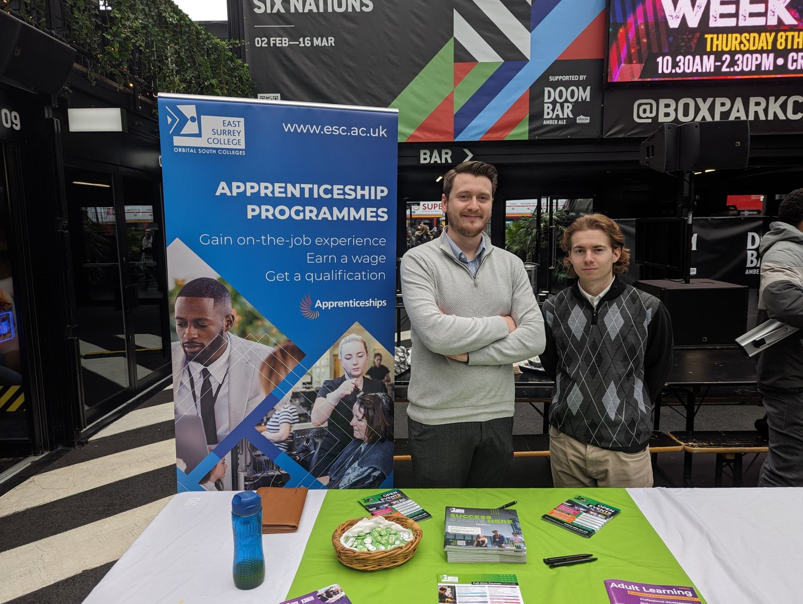 Mark and Nathan standing at a Careers Fair stand